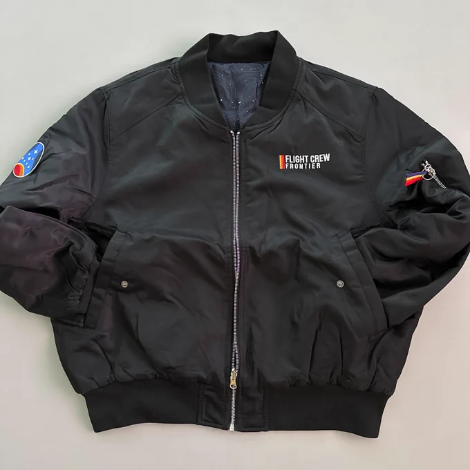 A black bomber jacket with the words "Flight Crew Frontier" on the chest and a Constellation patch on the shoulder