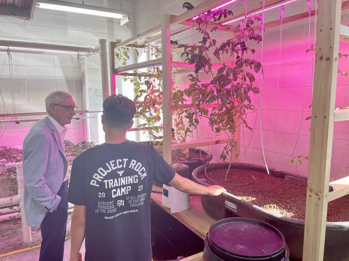 Gov. Evers views a student's aquaponics and hydroponics project.