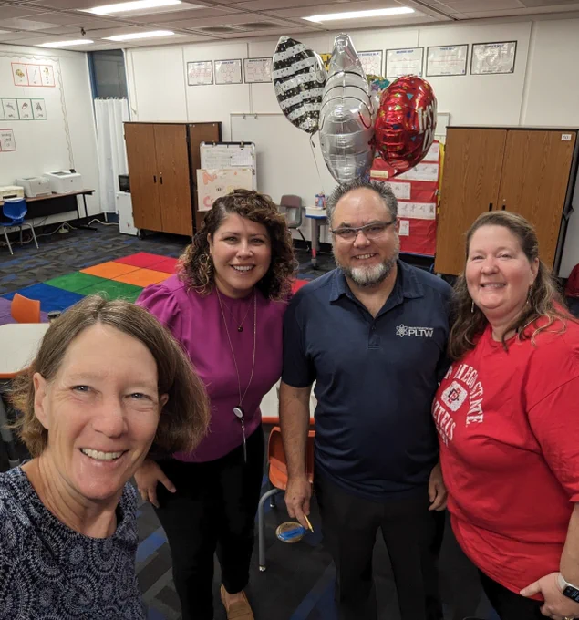Stacy Kline, Jessica Reyes, and Wendy Hammitt sharing the news with principal Jaime Ramirez of Roosevelt Walker Academy, that he was named outstanding administrator for PLTW for 2023-2024!