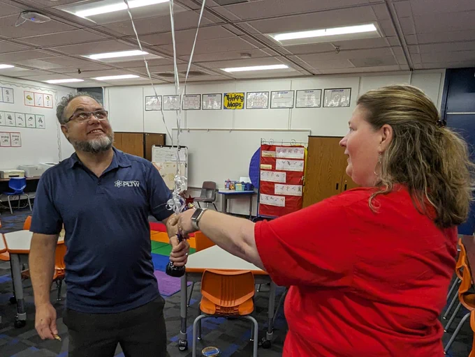 Stacy Kline, Jessica Reyes, and Wendy Hammitt sharing the news with principal Jaime Ramirez of Roosevelt Walker Academy, that he was named outstanding administrator for PLTW for 2023-2024!