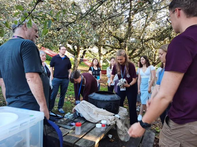 People gathered around a moth trap
