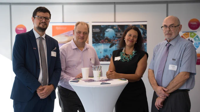 Three men and one woman, all researchers and innovators, stand for a group photo