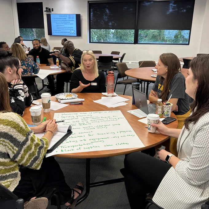 Photo of people sitting at tables having discussions.