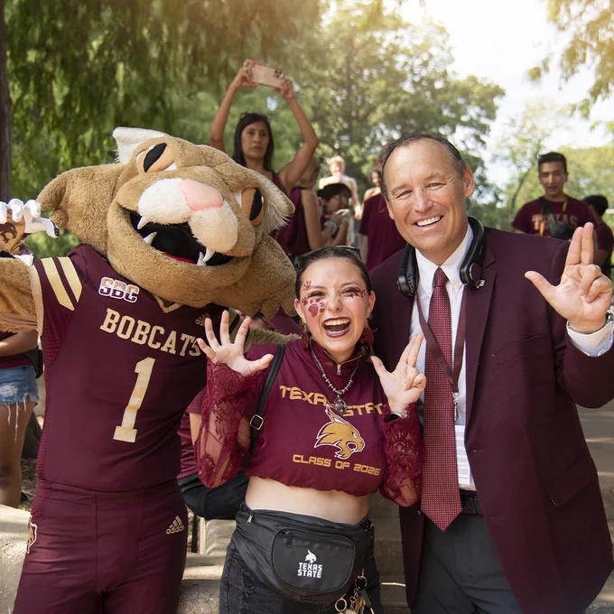 President Damphousse, Boko and a student posing for picture.