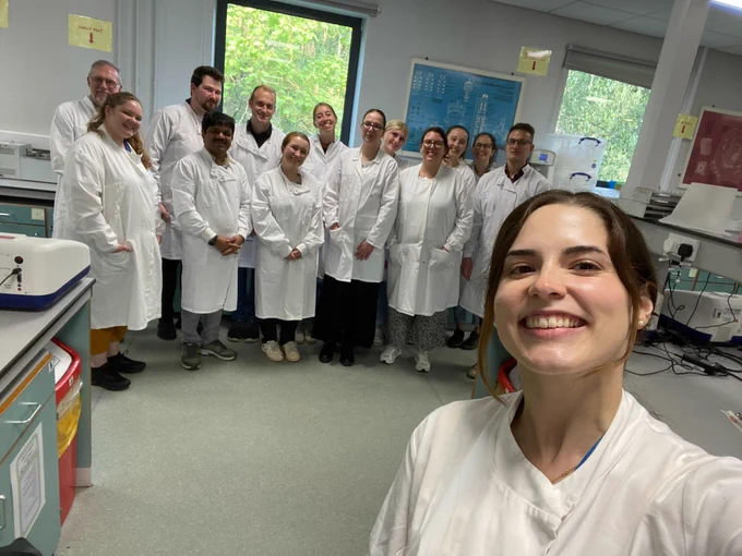 A group of people in a laboratory, in white lab coats.