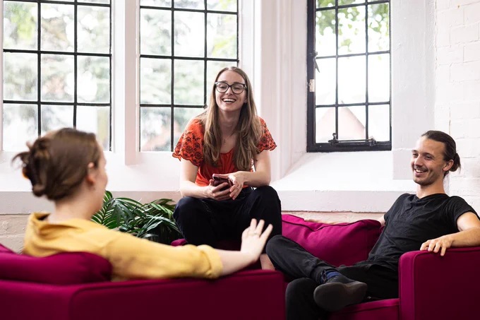Photo of three students sitting and laughing together.