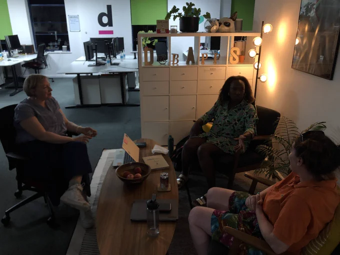 three women in animated conversation around a coffee table
