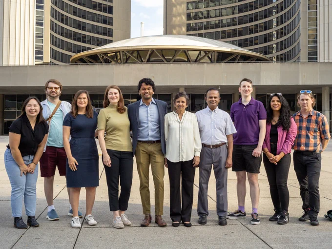 Kevin standing in front of Toronto City Hall with a group of friends and family