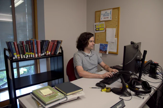 Ryan is hard at work on course reserves at his desk.