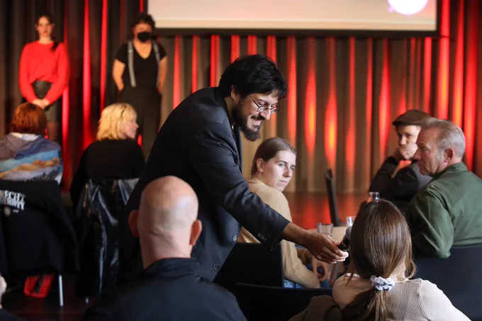 Moderator Sahand Sahendivai hands microphone to an audience member for a discussion at the Story Jam presentations during the Netherlands Film Festival 2022