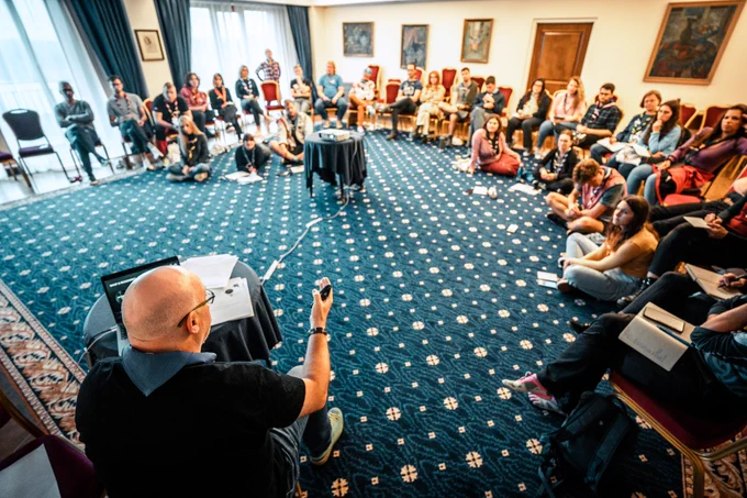 A man facilitates a session in front of a group of young Scouts and Guides.