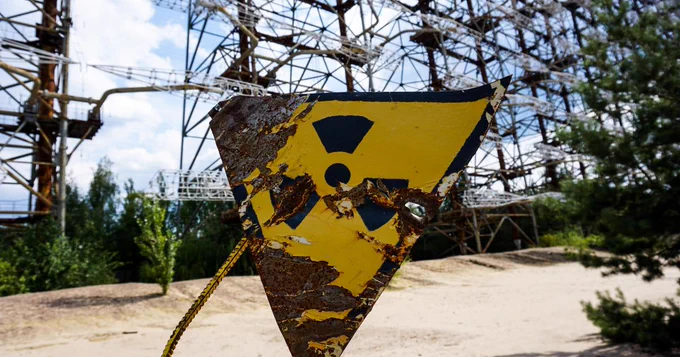 A rusted radioactive warning sign outside Chernobyl
