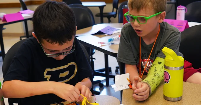 2 boys work on an electricity experiment