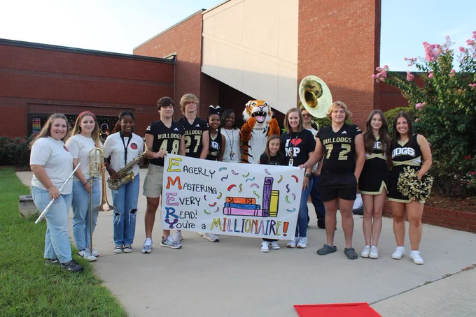 Group shot of Emery with MPHS cheerleaders, band, football players and Hubbard staff