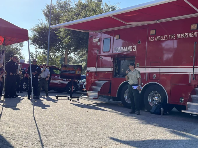 Angeles National Forest employees speaking in front of Los Angeles County Fire vehicle.