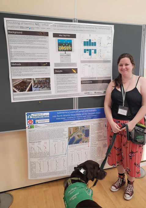 A young woman and her assistance dog stand in front of a research poster entitled doubling of benthic nitrite influx in the presence of macrofauna revealed by radioisotop3 method.