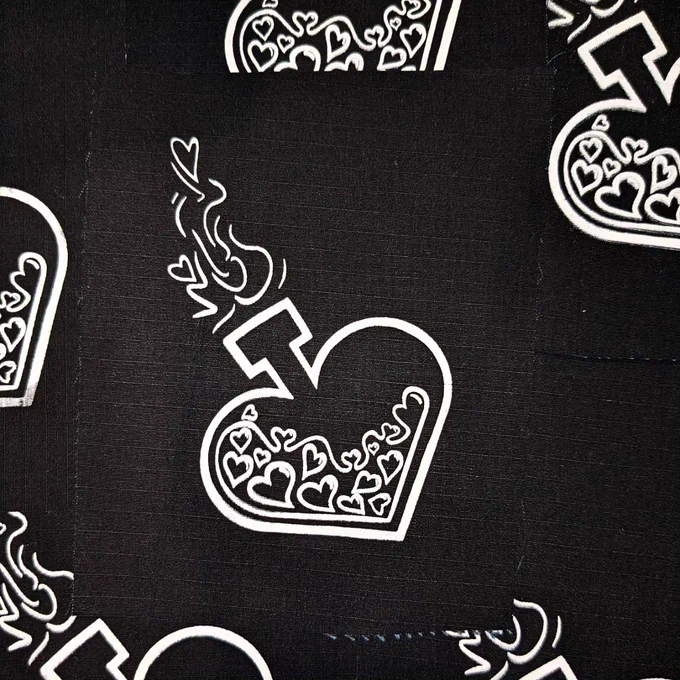 a black fabric patch with white ink that depicts a heart shaped bottle with liquid inside that's bubbles are also heart shaped. it has small heart shaped bubbles and smoke coming out of the top