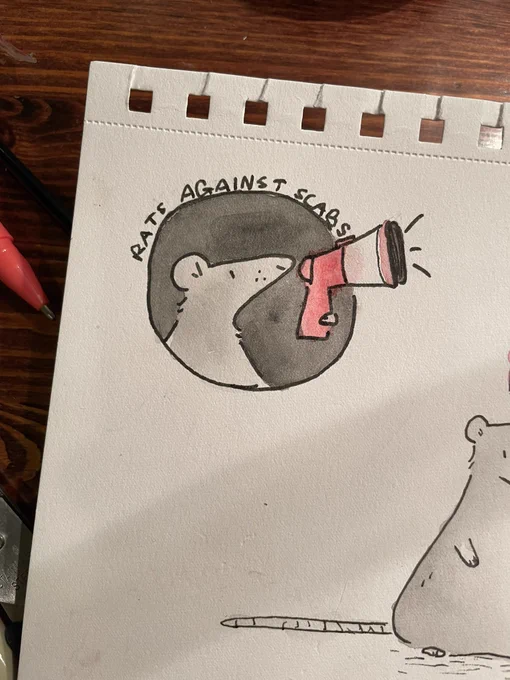 Rat with a megaphone. Above her it says “rats against scabs”