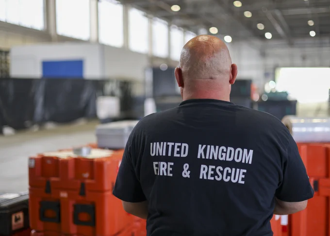 Image shows the back of a man with 'United Kingdom Fire & Rescue' on his t-shirt.