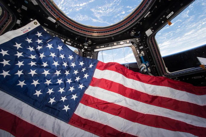 The American flag floats in the International Space Station's cupola. The cupola has windows that gives crew members a 360-degree look at Earth as the space station orbits. Here, the planet's blue curvature is visible and takes up the top portion of the image. Credit: NASA