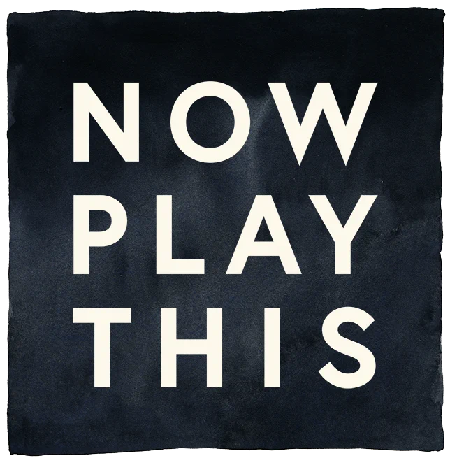 The now play this logo in a painted watercolour style. White text on a black background.
