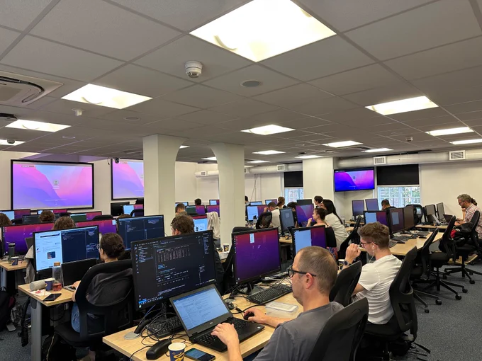 Room full of people coding at computers