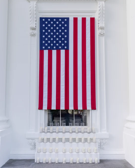 A display at the White House North Portico featuring candles and the American flag in honor of 9/11.
