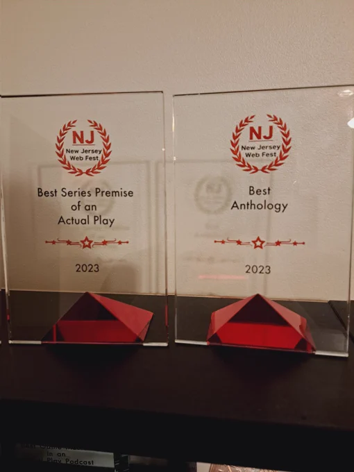 The award trophies for Best Series Premise of an Actual Play, and Best Anthology Podcast, from NJ Web Fest 2023.