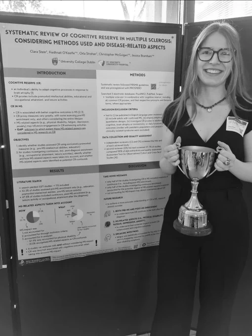 Clara Stein holding the DoN early career award perpetual trophy beside her research poster called Systematic Review of Cognitive Reserve in MS: considering methods used and disease related aspects 