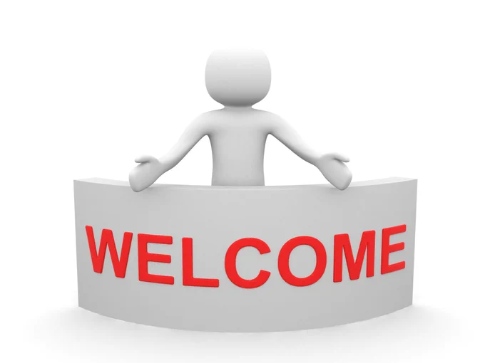 A white humanoid figure holding a welcome sign