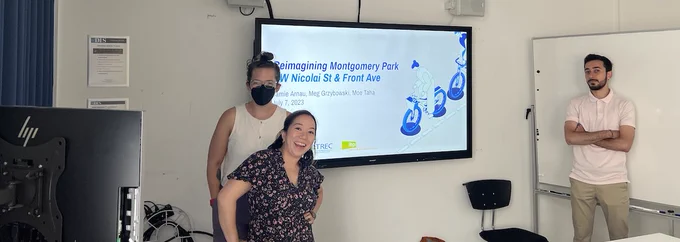 Presenters standing in front of a screen with a slideshow