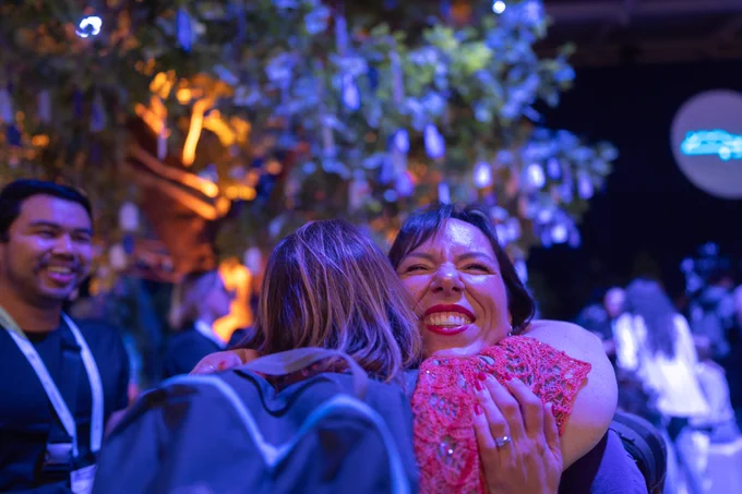 Two Trailblazers hugging under the Tree of Gratitude. 