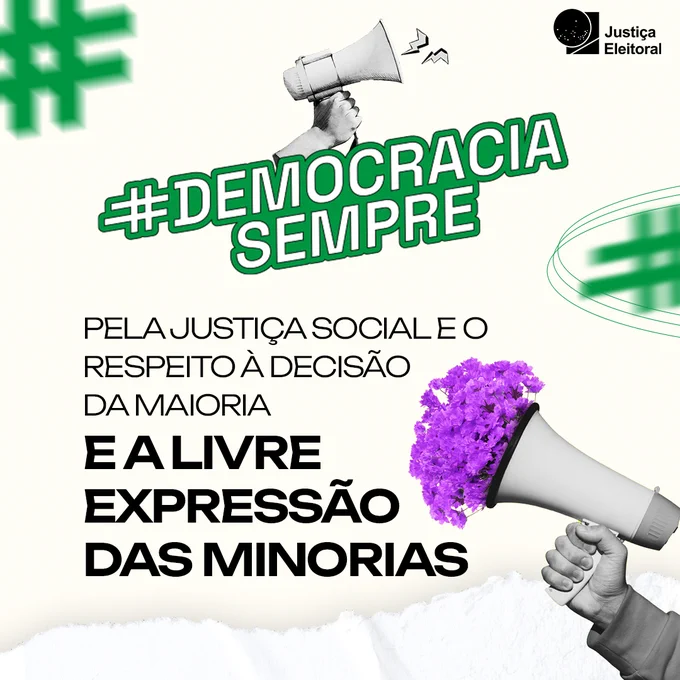 Abaixo da hashtag, está o texto: "Pela justiça social e o respeito à decisão da maioria e a livre expresão das minorias". A passagem "e a livre expressão das minorias" está destacada. À direita do texto, tem uma imagem de uma mão segurando um megafone, em preto e branco, com flores coloridas em roxo saindo do objeto. No canto superior direito está a marca da Justiça Eleitoral.