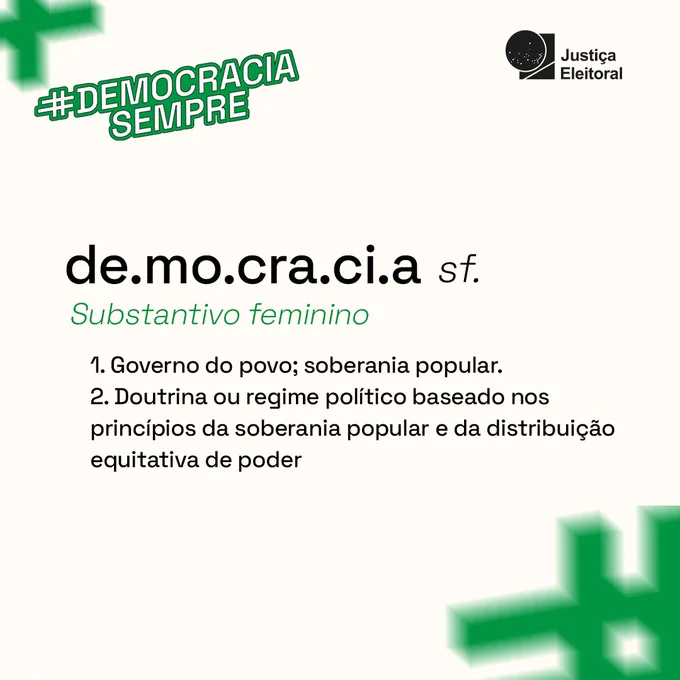 no canto superior esquerdo o selo “#DemocraciaSempre” e a logomarca da “Justiça Eleitoral” no canto superior direito. No centro, à esquerda, o título: “de.mo.cra.ci.a sf. Substantivo feminino” seguido das definições do termo enumeradas “1. Governo do povo; soberania popular. 2. Doutrina ou regime político baseado nos princípios da soberania popular e da distribuição equitativa de poder”. O fundo é branco com duas cerquilhas embaçadas, popularmente conhecidas como “jogo da velha” e usadas em hashtags, uma no canto superior esquerdo e a outra no canto inferior direito.