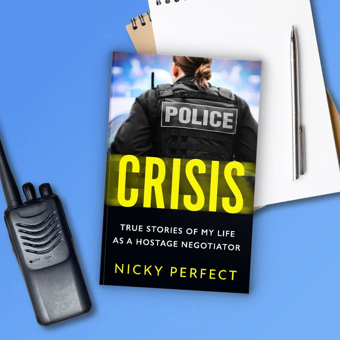 Image shows the cover of Crisis against a blue background. In the background is a walkie talkie and a notepad and pen.