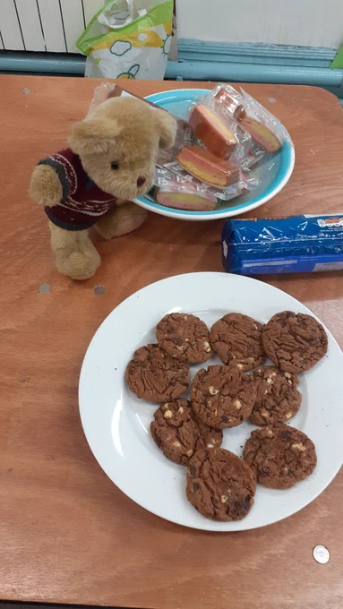 Repair Bear looks at a plate of cakes and biscuits. 