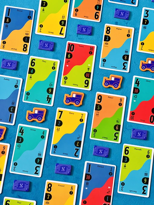 Cards are arranged in a tessellating pattern. Each card is divided in two across the diagonal. Each half has a number and a related colour. In between the cards are small purple dollar tokens, and orange van shaped tokens
