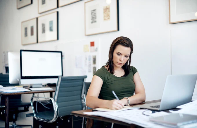 A young female sitting at a laptop.