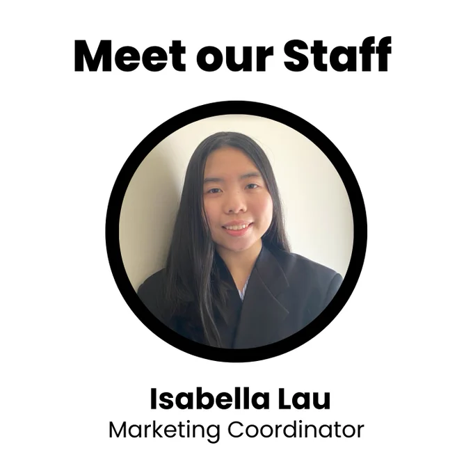 An image of a girl with long, straight, and black hair wearing a black suit. She is smiling and standing in front of a blank wall. Text on the image reads: “Meet our Staff. Isabella Lau; Marketing Coordinator.”