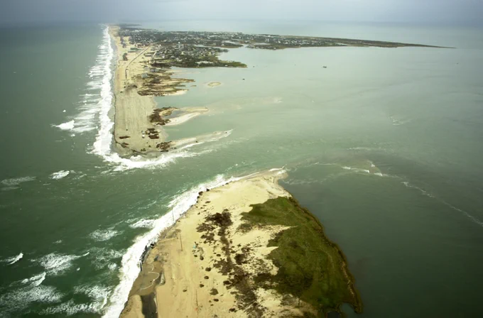 An aerial photo shows a breach in the land that was washed away by Hurricane Isabel, with Hatteras Village at the top of the photo. The bottom half shows land separated from the stretch.