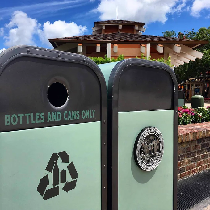 Green Disney Springs trash cans with a plaque denoting that the shopping area is a "Source of Inspiration"