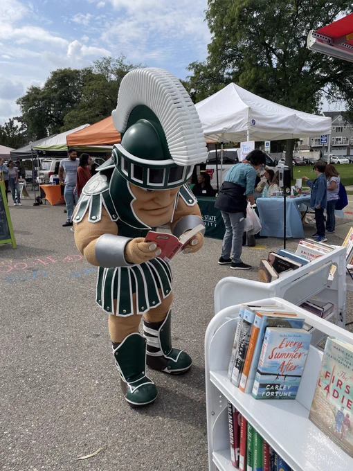 Sparty reads a book from the Library on the Go. 