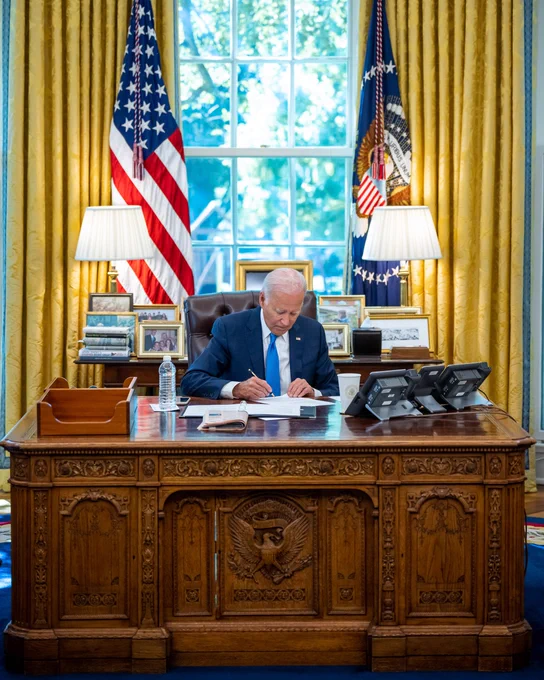 President Biden works at the Resolute Desk in the Oval Office.
