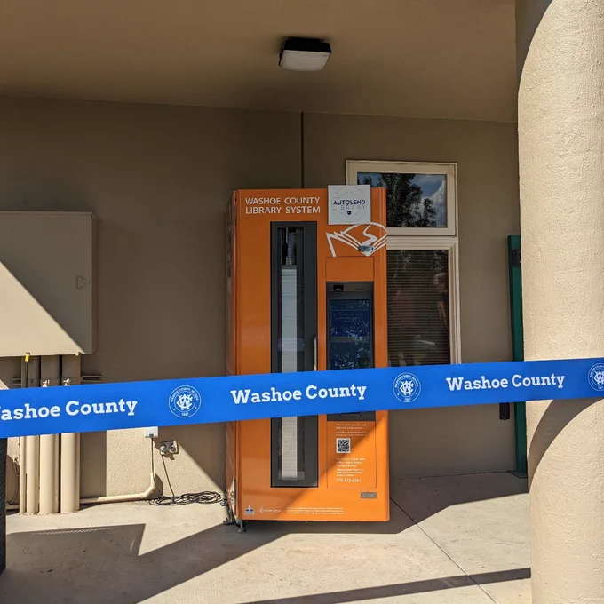 Photo two shows the bright orange library to go kiosk in front of the Sun Valley Neighborhood Center.