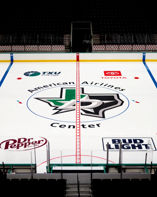A portrait photo from above of center ice at the aac, featuring the txu logo in top left, toyota logo top right, dr pepper logo bottom left and bud light logo bottom right with the aac logo at center ice and the dallas stars "texas" state logo in center ice, blown up as large as possible to fill the center ice, and split by the center ice red line with the texas state outline in it