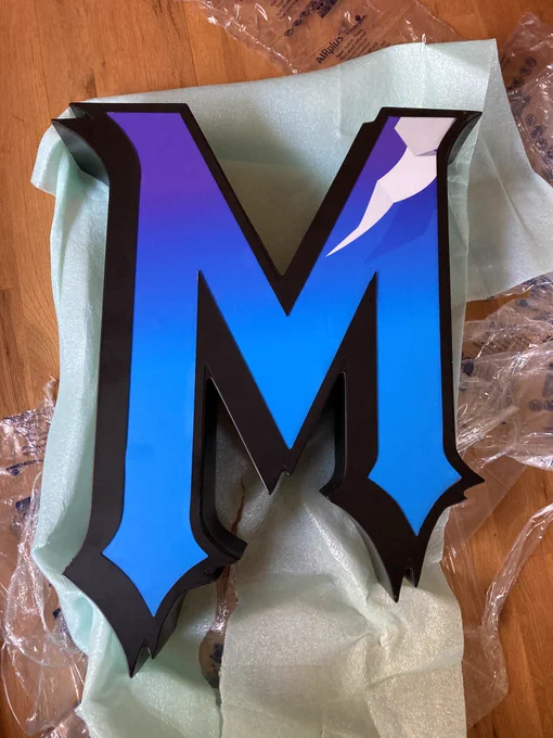 One of the packages is unwrapped. It is a stylized letter M.