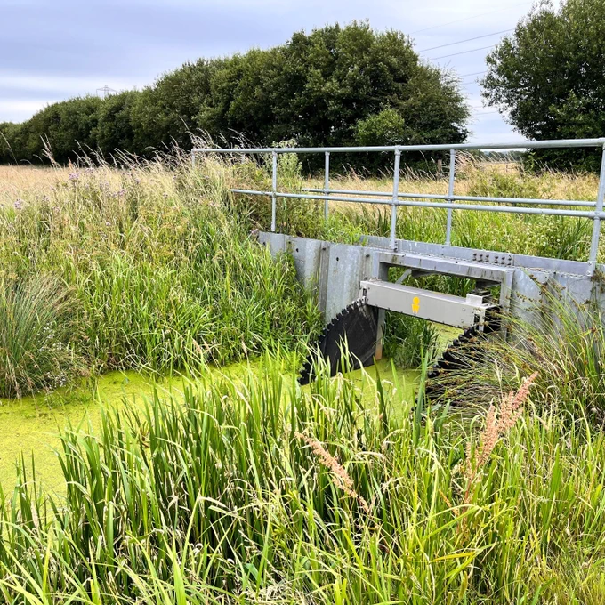 Photo of a tilting wier surrounded by peatland