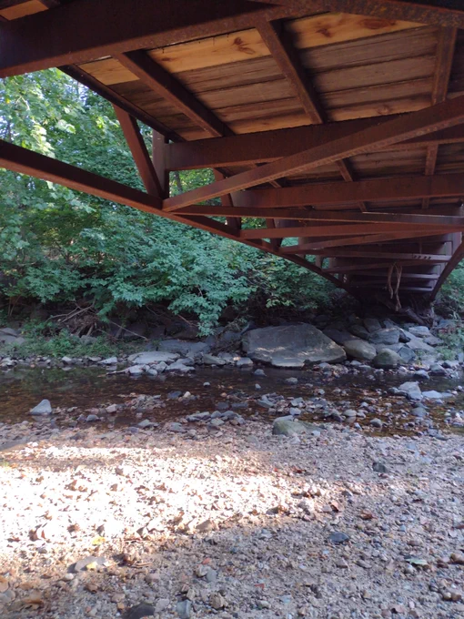 Photo of a creek taken from a spot under a footbridge.