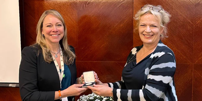 President of the Scandinavian Physiological Society, Prof Helle Prætorius Øhrwald giving Lora a medal