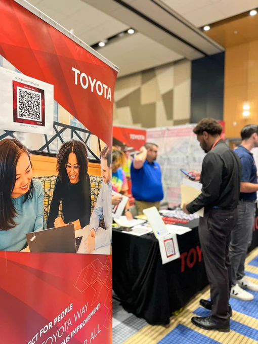 Toyota table with student scanning a QR code at the engineering and computer science career fair.